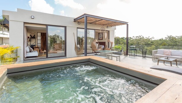 A modern house with a swimming pool, glass doors, and outdoor furniture. - Luxury Penthouse Suite Private Pool X17 (Tulum)