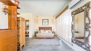 A bedroom with a large bed, wooden furniture, a mirror, and a bamboo partition. - Luxury Penthouse Suite Private Pool X17 (Tulum)