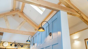 A room with exposed wooden beams, a skylight, and pendant lighting. - 3 bedroom accommodation in Llanboidy (Llanboidy)