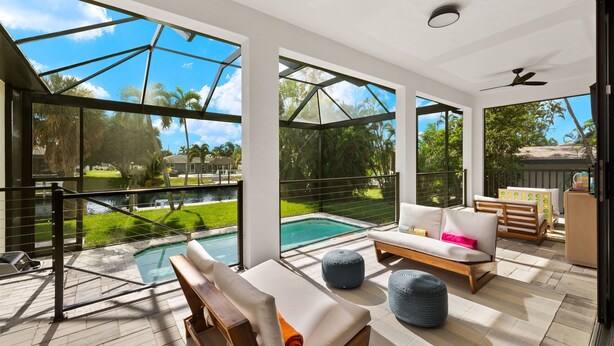 Amplio espacio al aire libre con piscina, sillas de descanso y vistas a un paisaje tropical.