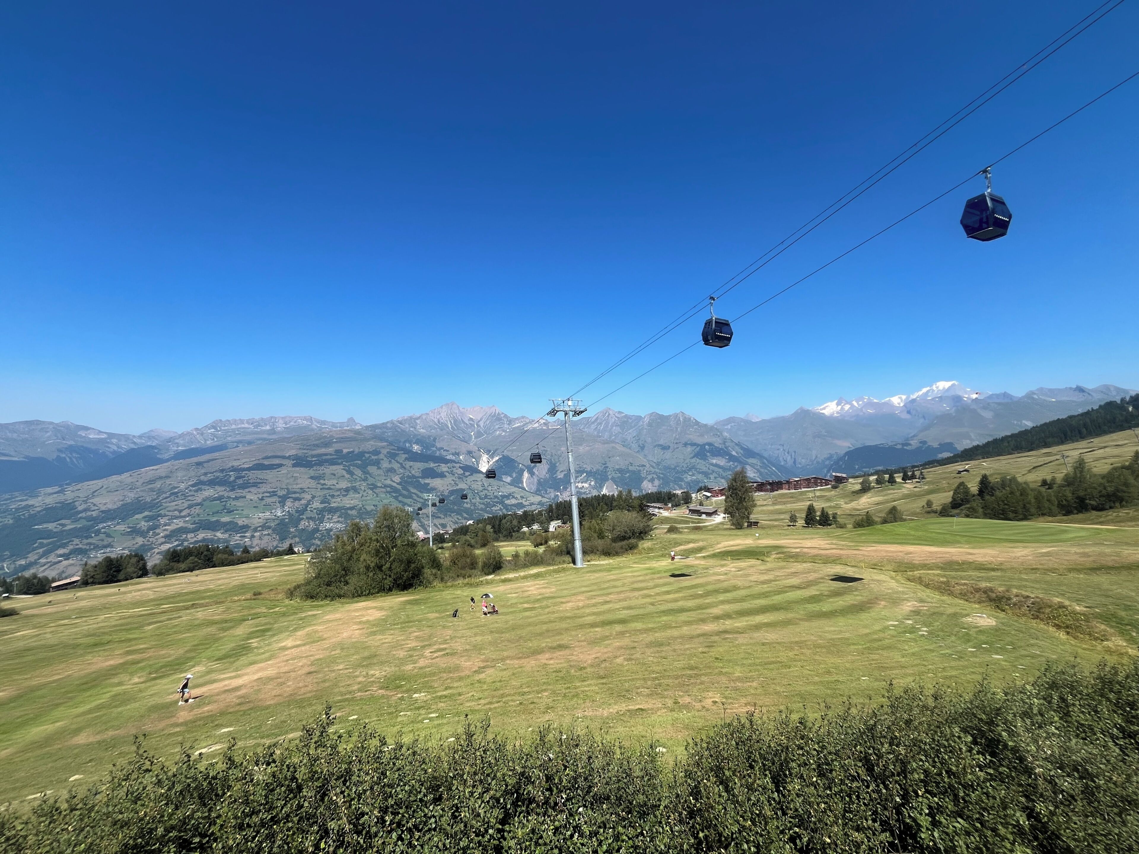 Un sistema de teleférico en una zona montañosa con cielo despejado.