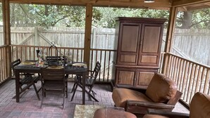 An outdoor patio with a wooden table, chairs, a cabinet, and a ceiling fan. - Preakness Corner, Cheerful, cozy 4 bedroom home (Marietta)