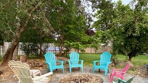 A patio area with Adirondack chairs and a fire pit. - Spacious Custom Retreat with a Pool! (Central Point)