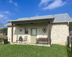 A stone building with a green door, a star emblem, and outdoor seating.