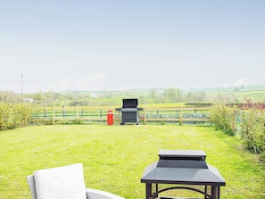 A grassy outdoor area with a barbecue grill, a table, and a bench. - 1 bedroom accommodation in Lane Ends, near Bolton by Bowland (Lane Ends, near Bolton by Bowland)