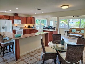 Enjoy meals in the kitchen with an oven and microwave, surrounded by a large window offering a view of the outdoors.