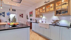 Una cocina con isla central, armarios de madera y una variedad de utensilios de cocina.