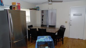 Une cuisine de taille réduite, équipée d’un réfrigérateur, d’une table à manger et de chaises.