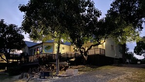 A residential area with houses, a wooden deck, and a gravel driveway. - The Lodge on Salado Creek includes golf cart (Salado)