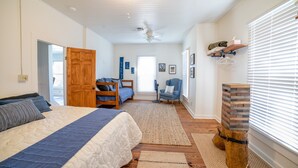 A bedroom with a large bed, a wooden door, a desk, and a chair. - The Lodge on Salado Creek includes golf cart (Salado)