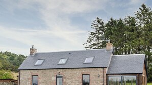 A stone house with a sloped roof, multiple windows, and a stone wall in front. - 3 bedroom accommodation in Dundee (Dundee)