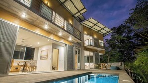 A modern two-story house with a swimming pool, large windows, and a balcony. - 2BR, 2.5BA, Jungle views, walk to beach, Pool, AC (Nicoya)