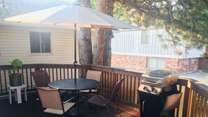 A covered outdoor patio with a round table and chairs, a grill, and a potted plant. - 1,200 SqFt Comfy Home, 15 min to Boulder (Broomfield)