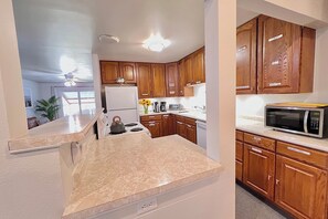 A kitchen with wooden cabinets, a microwave, and a stove.