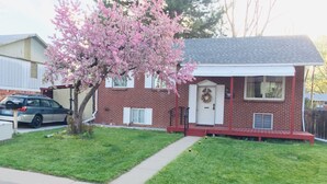 A two-story brick house with a front porch, a garage, and a driveway. - 1,200 SqFt Comfy Home, 15 min to Boulder (Broomfield)