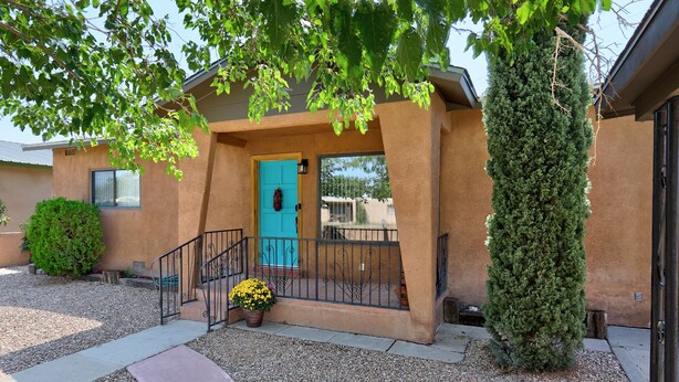 A house with a blue door, a staircase, and a potted plant. - 5 min  to Old Town - Prime location - Game Room - gated parking  (Albuquerque)