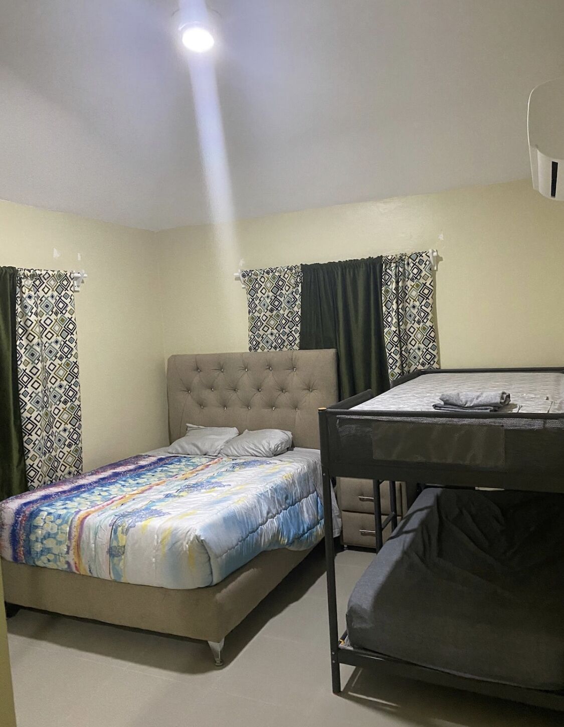 Un dormitorio con una cama, literas y un escritorio.