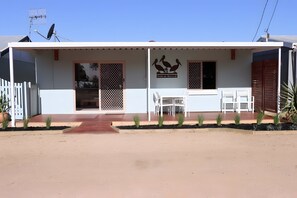 Un bâtiment doté d’un porche couvert, d’une antenne parabolique et d’un logo représentant « Pelican Retreat ».