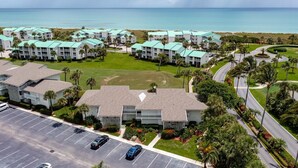 A resort with multiple buildings, a parking lot, and a view of the ocean. - 🏖️Just Remodeled! The Ocean Cottage at Ocean Village Beach Condo (Fort Pierce)