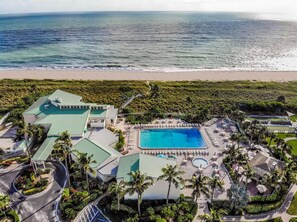 An aerial view of a resort with a large swimming pool, multiple buildings, and a beach in the background. - 🏖️Just Remodeled! The Ocean Cottage at Ocean Village Beach Condo (Fort Pierce)