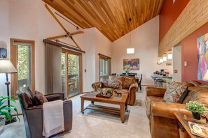Living Room with plush leather furnishings, 50" TV, gas fireplace, piano, wall-mounted stereo system, and private balcony access