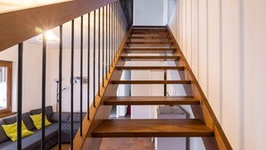 A modern staircase with wooden steps and black railings, leading to an upper floor. - Casa di Nonno by Interhome (Cividale)