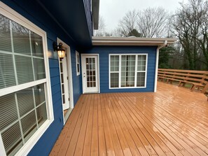 Ein blaues Haus mit einer Holzdiele und einer weißen Tür.