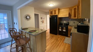 A kitchen with wooden cabinets, a black refrigerator, and a granite countertop. - Beautiful House 4 ENTIRE Family near Suntrust Park (Marietta)
