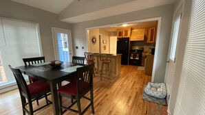 A dining area with a wooden table and chairs, a kitchen in the background, and a small play area with toys. - Beautiful House 4 ENTIRE Family near Suntrust Park (Marietta)