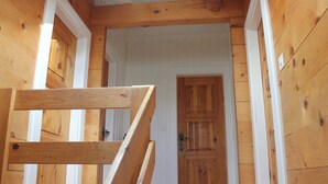 Una escalera de madera que conduce a una habitación con una puerta de madera.