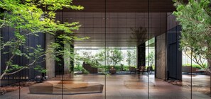 Ein modernes Interieur mit Glastrennwand, Zimmerpflanzen und einer Sitzecke.