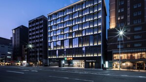 A modern hotel with multiple floors, large windows, and a prominent 'LIFE' sign. - Richmond Hotel Premier Kyoto Shijo (Kyoto)