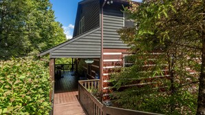 A wooden deck leading to a building with a sloped roof and a covered porch area. - Amen Corner - Close to Boone! Hot Tub, Pet Friendly, Ping Pong, Foosball, Mountain Views (Vilas)