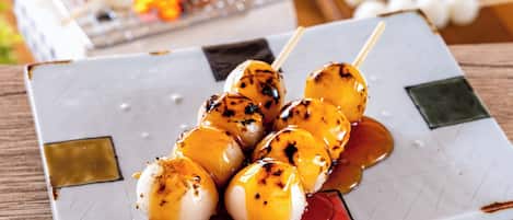 Un plato de brochetas con salsa.