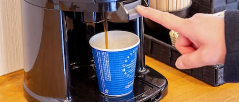 A coffee machine dispensing coffee into a blue cup.