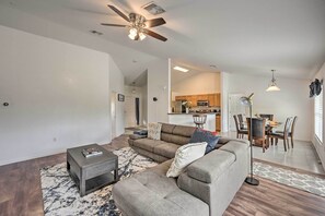 A spacious living room with a sofa, coffee table, and a dining area with a table and chairs.