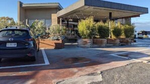 A modern building with a flat roof and a covered area. There is a car parked in front. - Treetops-Large Home 9km to CBD Sleeps 10. (Taroona)