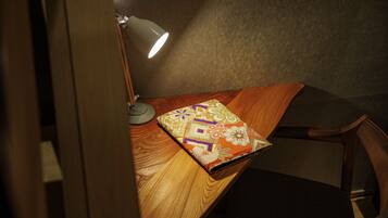 Ein Holztisch mit einem gemusterten Notizbuch, einer Schreibtischlampe und einem Stuhl.