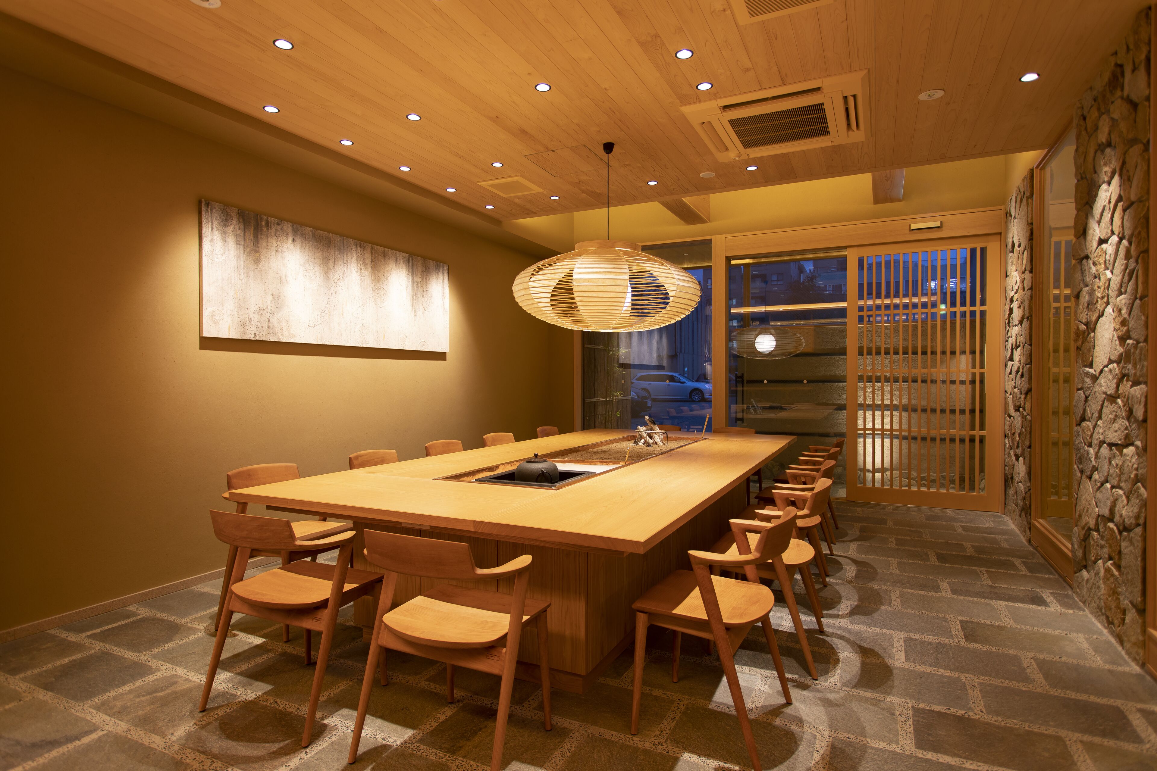 Un comedor moderno con una larga mesa de madera, varias sillas y una isla central.