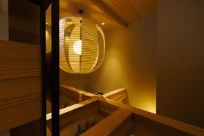Un intérieur en bois, avec un luminaire suspendu et un escalier.