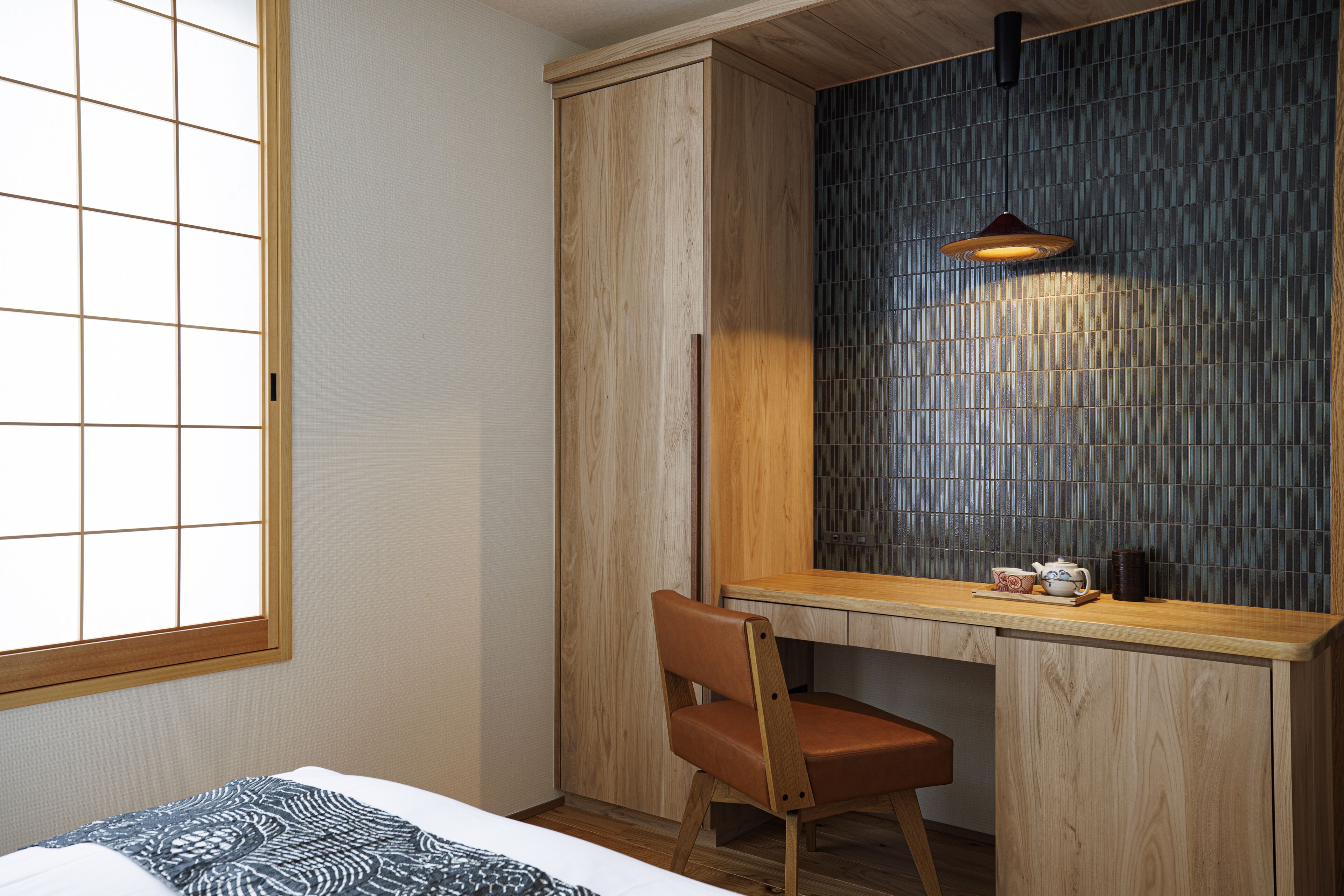 A bedroom with a wooden desk, a chair, a bed, and a window with a grid pattern.