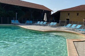 Relax by the serene pool surrounded by lounge chairs and a shaded area.