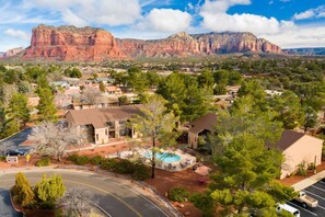 A residential area with houses, a swimming pool, and a mountain in the background.