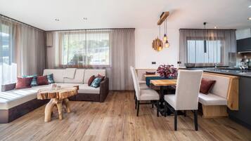 A modern living room with a sofa, dining table, and wooden coffee table.