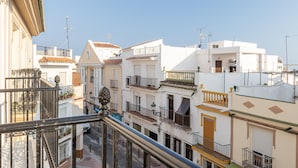 Une rue résidentielle bordée d’immeubles à plusieurs étages, dotés de balcons, et sous un ciel dégagé.