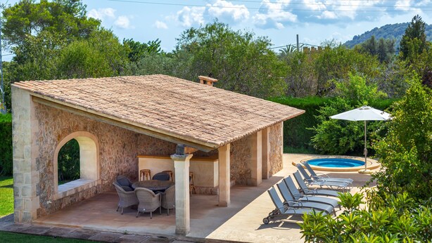 A stone-built outdoor patio with a pool, lounge chairs, and a dining area. - Holiday Home "Can Noble den Suau" with Pool, Hot Tub, Terraces & Garden (Pollensa)