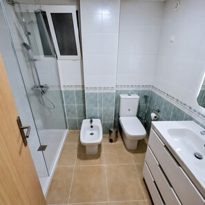 Ein Badezimmer mit Duschkabine, Bidet, Toilette und Waschbecken.