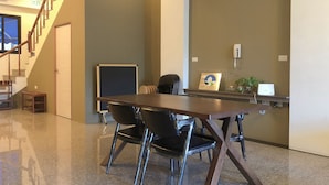 A conference room with a long table, black chairs, a clock, and a small plant on a shelf. - I Life Zili (Ji'an)