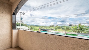 A balcony with a view of a green landscape and buildings in the distance. - I Life Zili (Ji'an)