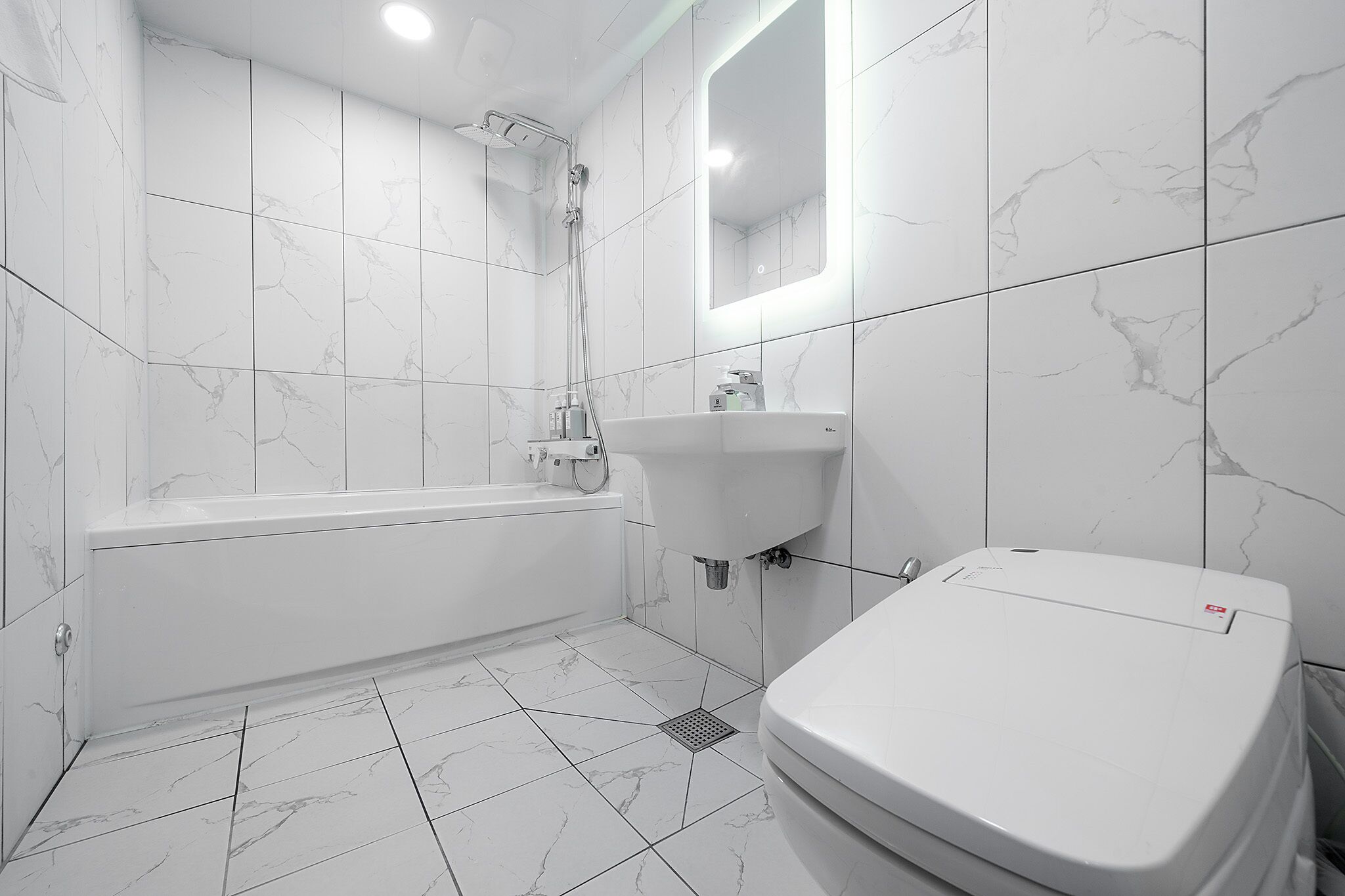 A modern bathroom with a bathtub, toilet, and sink.